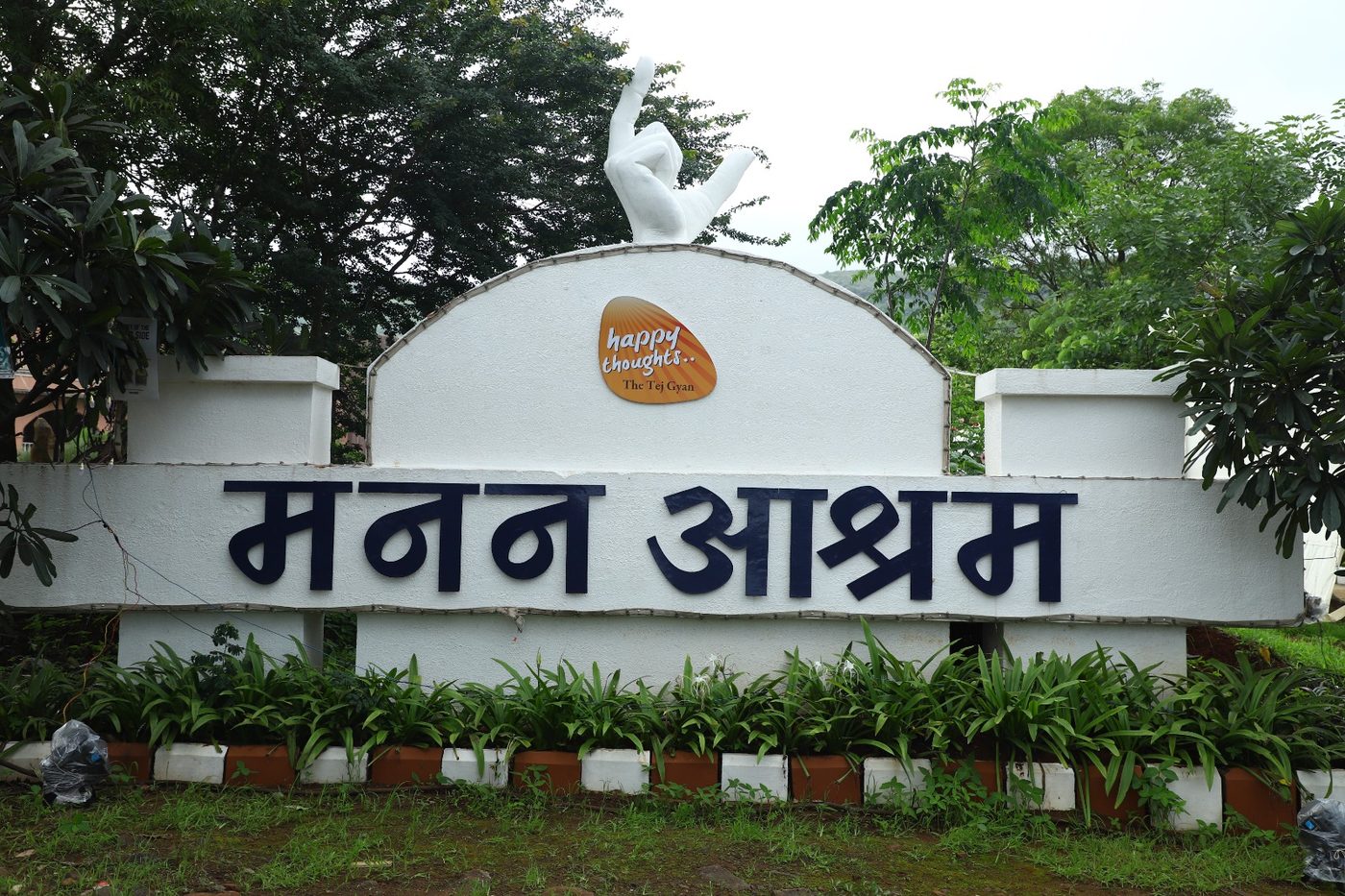 The MaNaN Ashram entrance sign, with the hills behind it