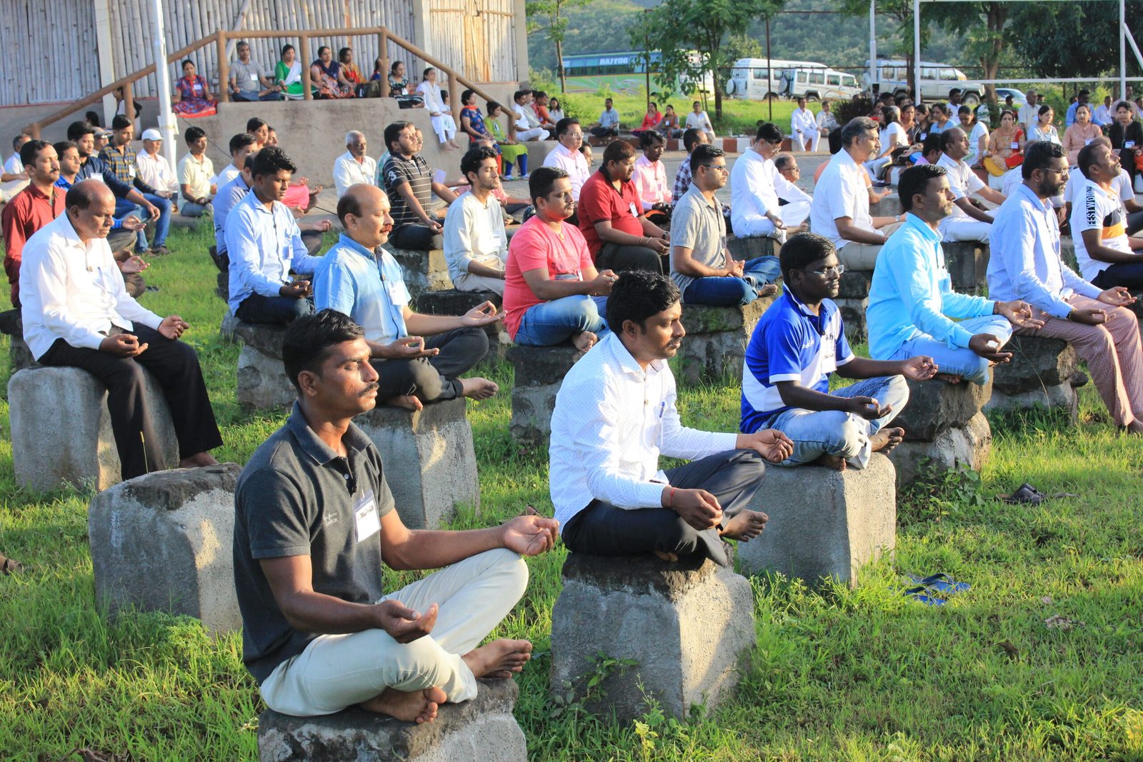 Seekers meditating on stone seats set into the hillside